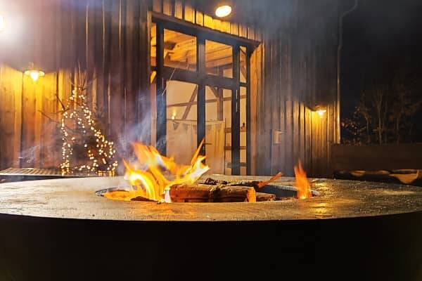 Cosy campfire in a fire bowl in front of the Hollerscheune - a perfect Christmas party location in the Upper Palatinate.