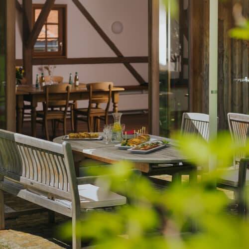 Eine Detailaufnahme der Terrasse der Hollermanufaktur mit angerichteten Häppchen auf dem Tisch, als Location für Teambuilding Events in den Hollerhöfen.