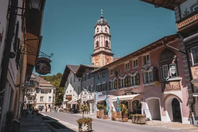 A road through a Bavarian village, beautiful buildings to the left and right and a church tower in the background - an example of the nature and culture that can be discovered on a holiday in the Upper Palatinate.