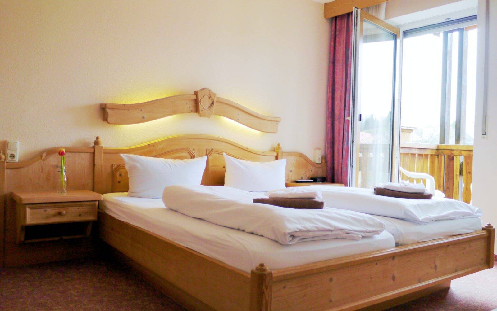 Ein Doppelbett aus Holz im Schlafzimmer des Landgasthofs Zum Hirschen.