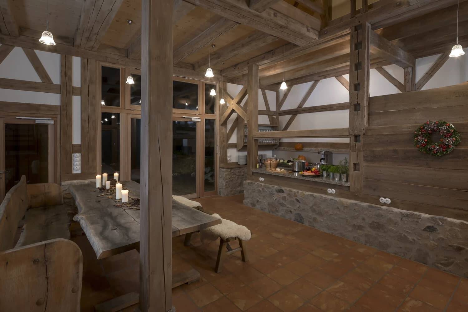 Ein Rendering des Innenraums in der Hollerscheune mit vielen Holzbalken und rustikaler Einrichtung.