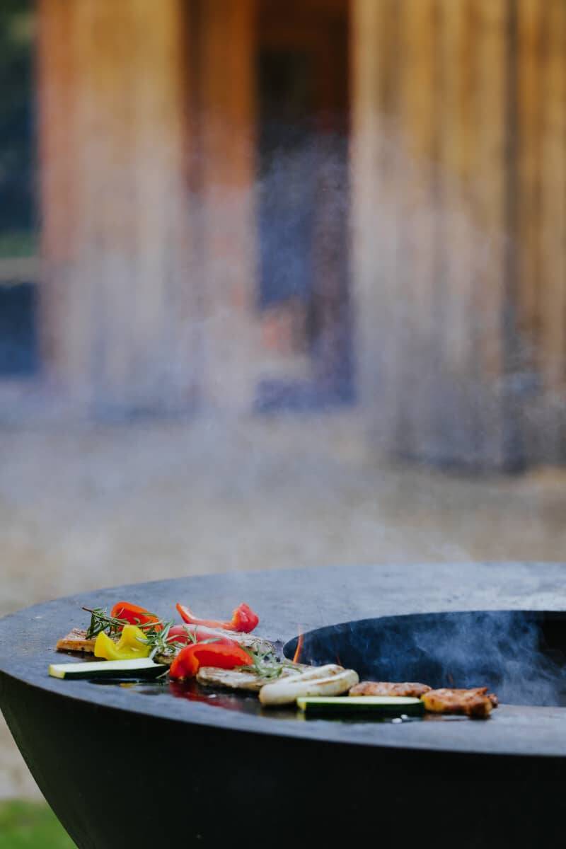 Frisch zubereitetes Grillfleisch und -gemüse auf der Feuerschale bei den Grillabenden in den Hollerhöfen.