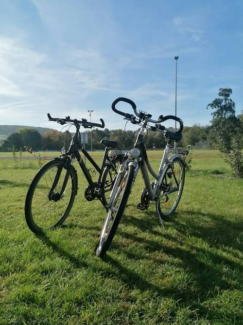 Two ladies' bikes on a green meadow.