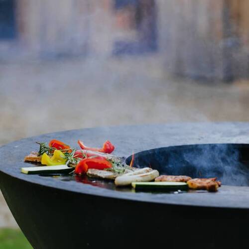 Gemüse und Fleisch brutzeln auf einem modernen Grill im Freien – ideal für gesellige Runden in der Feier Location mit Grill in den Hollerhöfen.